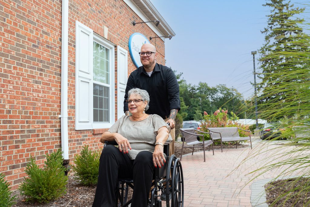 Care provider pushing woman in wheelchair.