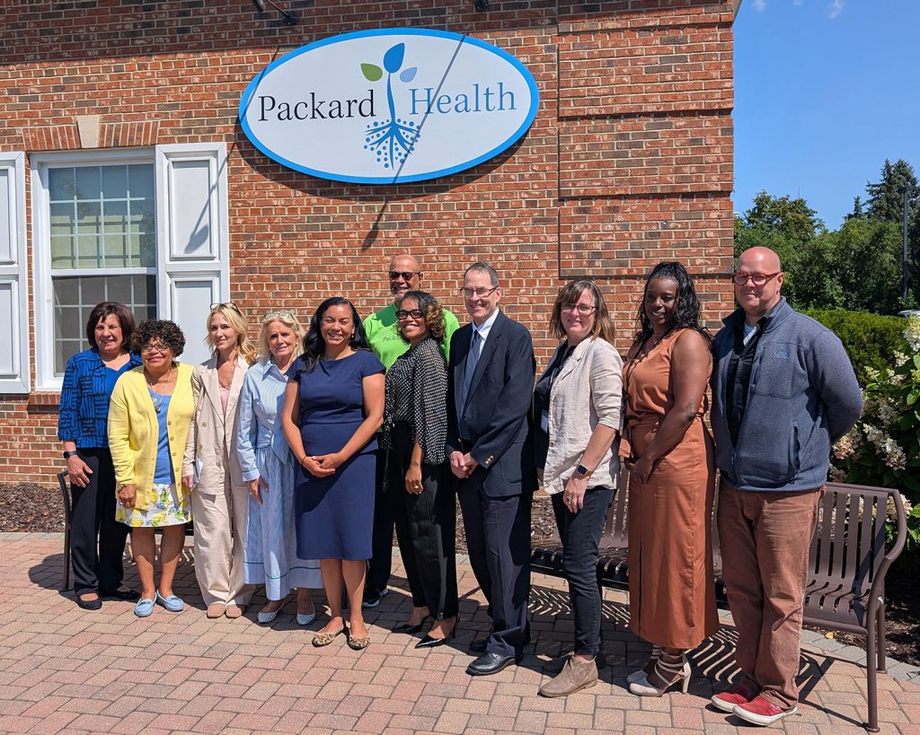 Representatives Dingell and Mejia at a standing outside Packard Health Carpenter clinic with Packard Health staff and board members