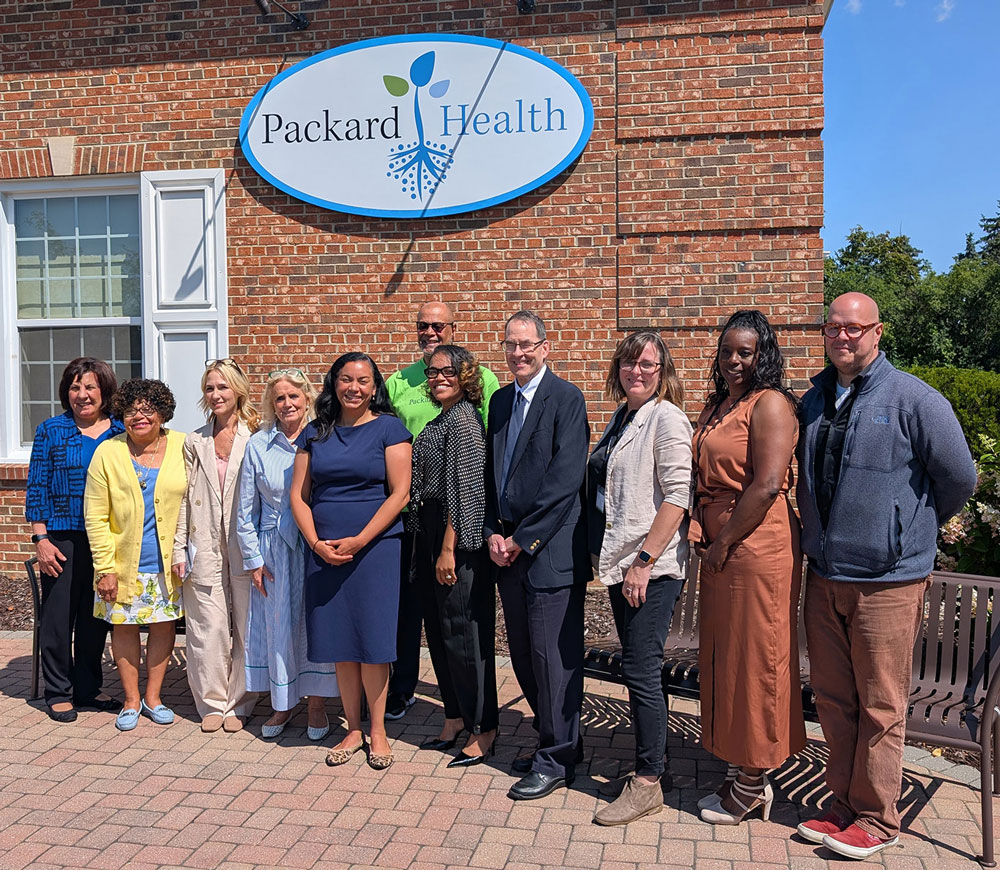 Representatives Dingell and Mejia at a standing outside Packard Health Carpenter clinic with Packard Health staff and board members